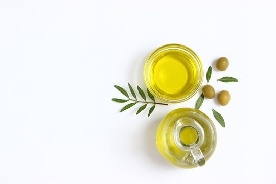 Olive oil, olives and green leaves.