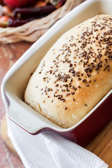 Homemade wheat bread with flax seeds in ceramic baking dish