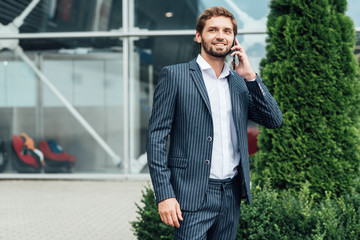 Smiling businessman using mobile phone	