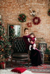 Obraz na płótnie Canvas Baby girl and mother near Christmas tree