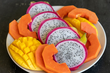 Tropical fruits assortment on a plate, close up