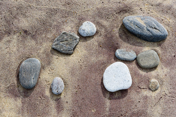 Beach red and yellow sand and sea stones