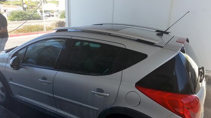 A man in a car wash, washes a dirty car.