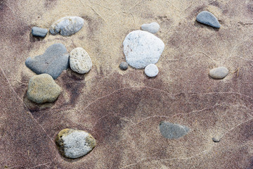 Fototapeta na wymiar Beach red and yellow sand and sea stones