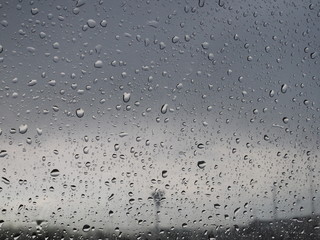 beautiful raindrops on the glass through which you can see the stormy gray sky