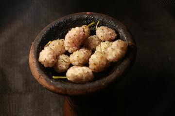 bowl with tobacco for hookah. fruits on a black background