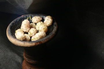 bowl with tobacco for hookah. fruits on a black background