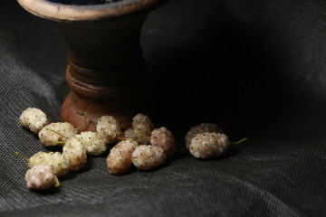 bowl with tobacco for hookah. fruits and berries on a black background. smoke hookah