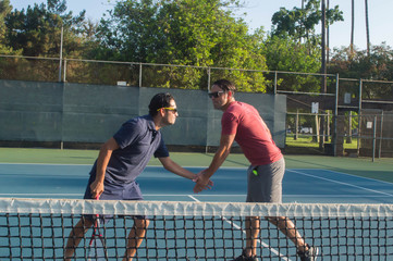 Men and women taking an outdoor tennis lesson