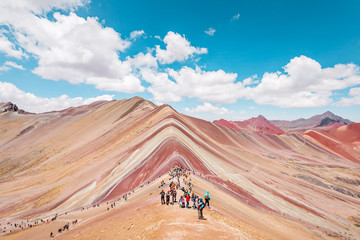 Vinicunca Rainbow Mountain, tourists standing on top of the mountain and admiring the view, Cusco, Peru