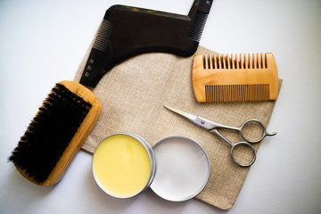 Expert beard care supplies such as comb, brush, scissor and wax made of natural ingredients. Flat...