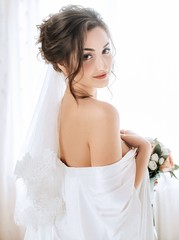 Beautiful brunette bride with stylish make-up in white dress