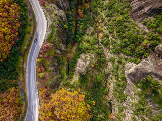 Birds eye view of a car passing through the colorful Meteora Monasteries in Greece in fall
