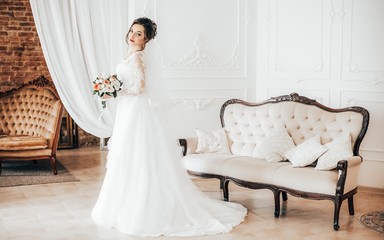 Fototapeta na wymiar Beautiful brunette bride with stylish make-up in white dress