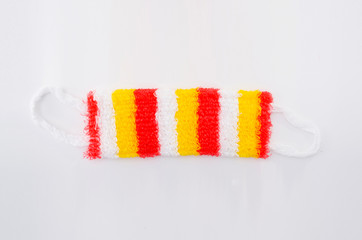 Multi-colored washcloth crocheted from polypropylene on a white background top view