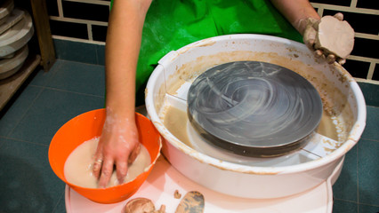 A raw clay pot in the hands of a potter. Workshop in the pottery workshop