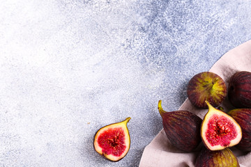 Whole and halved ripe organic delicious figs. Healthy nutritious vegan snack full of fiber and antioxidants, rich on variety of vitamins and minerals. Close up, copy space, top view, background.
