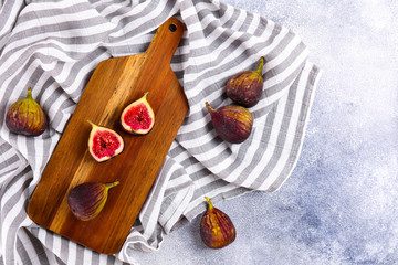 Whole and halved ripe organic delicious figs. Healthy nutritious vegan snack full of fiber and antioxidants, rich on variety of vitamins and minerals. Close up, copy space, top view, background.