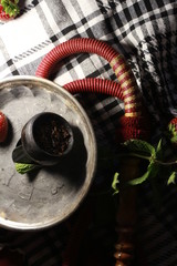 bowl with tobacco for hookah. fruits on a black background. smoke hookah