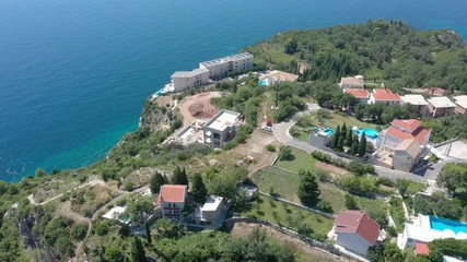 Drone flies above the coastline of the Adriatic sea, southern Montenegro, in a sunny summer day. Water in the sea is turquoise, clean and clear