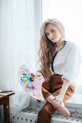 Portrait of beautiful young blonde woman with makeup  in fashion clothes