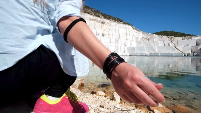 Attractive female with hat playing with starr boat toy on marble lake in Pamukkale, concept of happiness, love, escape, hope, childhood, forever young