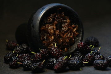 bowl with tobacco for hookah. berries on a black background