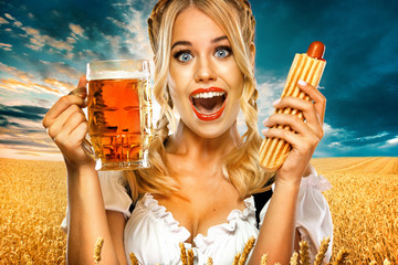 Young sexy Oktoberfest girl waitress, wearing a traditional Bavarian or german dirndl, serving big beer mugs with drink and french hot dog isolated on yellow background.