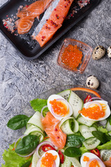 fresh  gourmet salad with  red  salmon caviar and  eggs and vegetables. close up.  Protein luxury delicacy  healthy food. beautifull served. flat lay