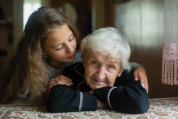 Portrait of elderly woman c beloved granddaughter in the house.