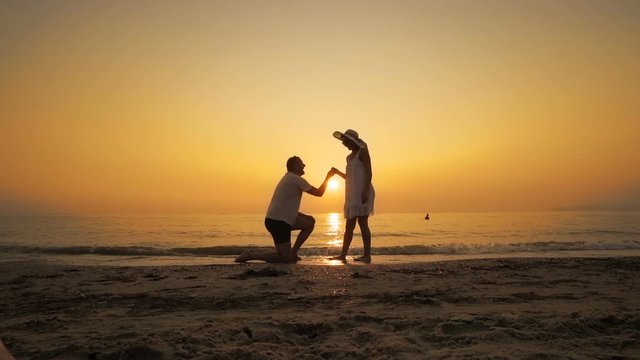 A man proposes on the beach at sunset, SLOW MOTION