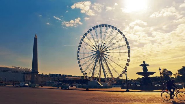 Hyperlapse of Egyptian Obelisk of Luxor at the center of the Place de la Concorde in Paris with rush hour traffic and shadow of the ferris wheel on asphalt