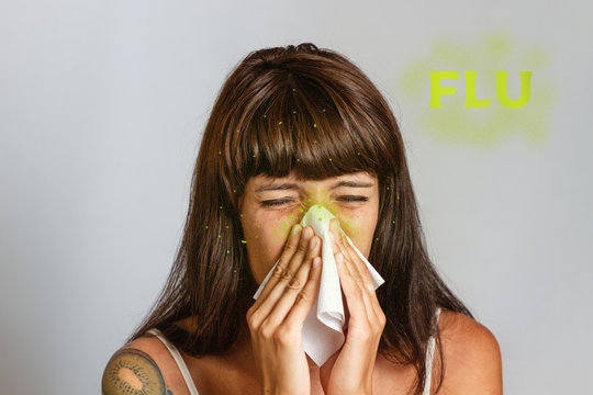 Colds and seasonal viral diseases. A brunette woman sneezes or blows her nose in a handkerchief. Text FLU and green microbs