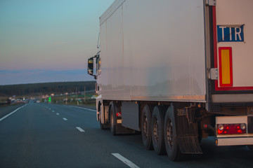 Obraz na płótnie Canvas truck goes on highway on sunset