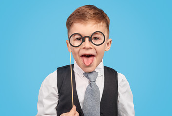 Boy in glasses showing tongue