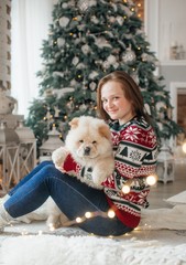 Happy girl with dog in Christmas decorations