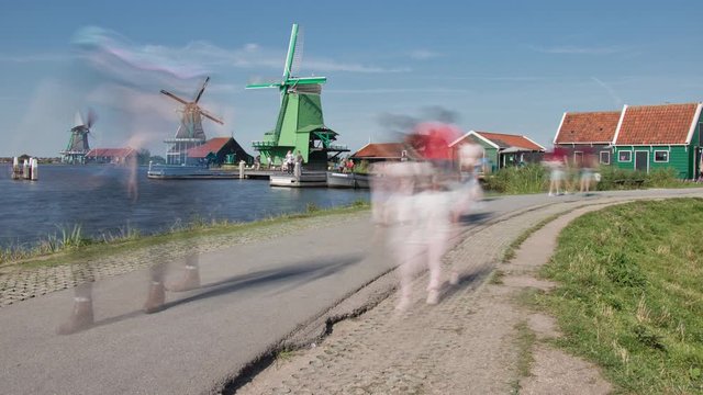 Zaandijk, Netherlands - AUGUST 25, 2019: Smooth motion blur time lapse of people walking a dike and taking pictures