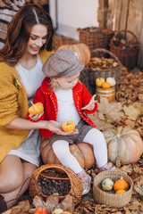 Beautiful baby girl in autumn garden with mother