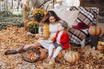 Beautiful baby girl in autumn garden with mother