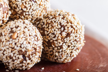 Energy balls cakes with almonds, sesame, cashew, walnuts, dates and germinated wheat, side view, close up.