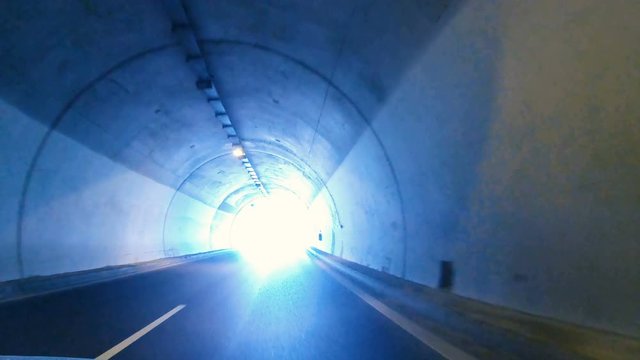 Driving pov on highway in tunnel and exit to light, concept of heaven