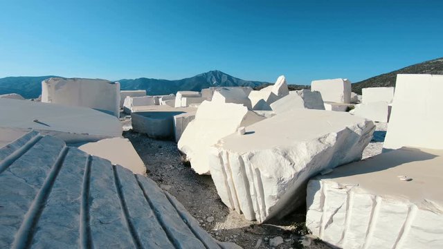 Walk at industrial marble quarry site with huge marble blocks