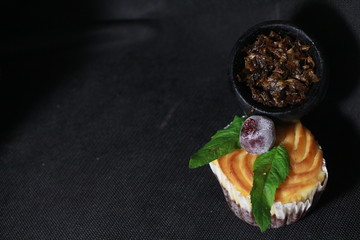 Obraz na płótnie Canvas bowl with tobacco for hookah. berries on a black background