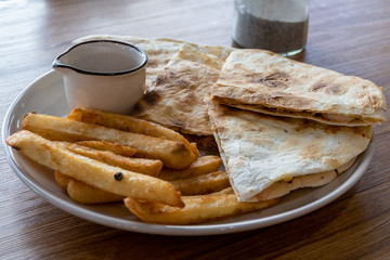 French fries and quesadilla on plate