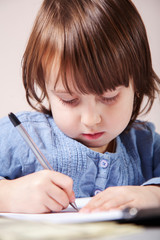 Little cute child girl learning and writing in a workbook. Concept of difficult path to success and victory in the future.