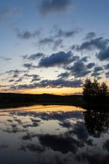 Fototapeta na wymiar Sunset at the lakeside in Finland during summer evening. Glowing orange horizon.