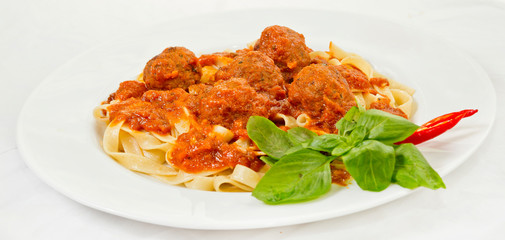 A plate of Fettuccine and Meatballs Pasta with Tomato Sauce.