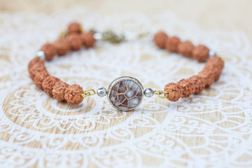 Mother pearl natural bead rudraksha seed bracelet on decorative background