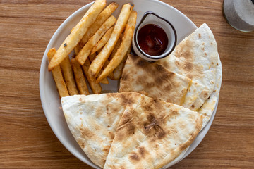 French fries and quesadilla on plate