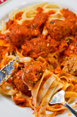 Fettuccine and Meatballs on a fork close-up.